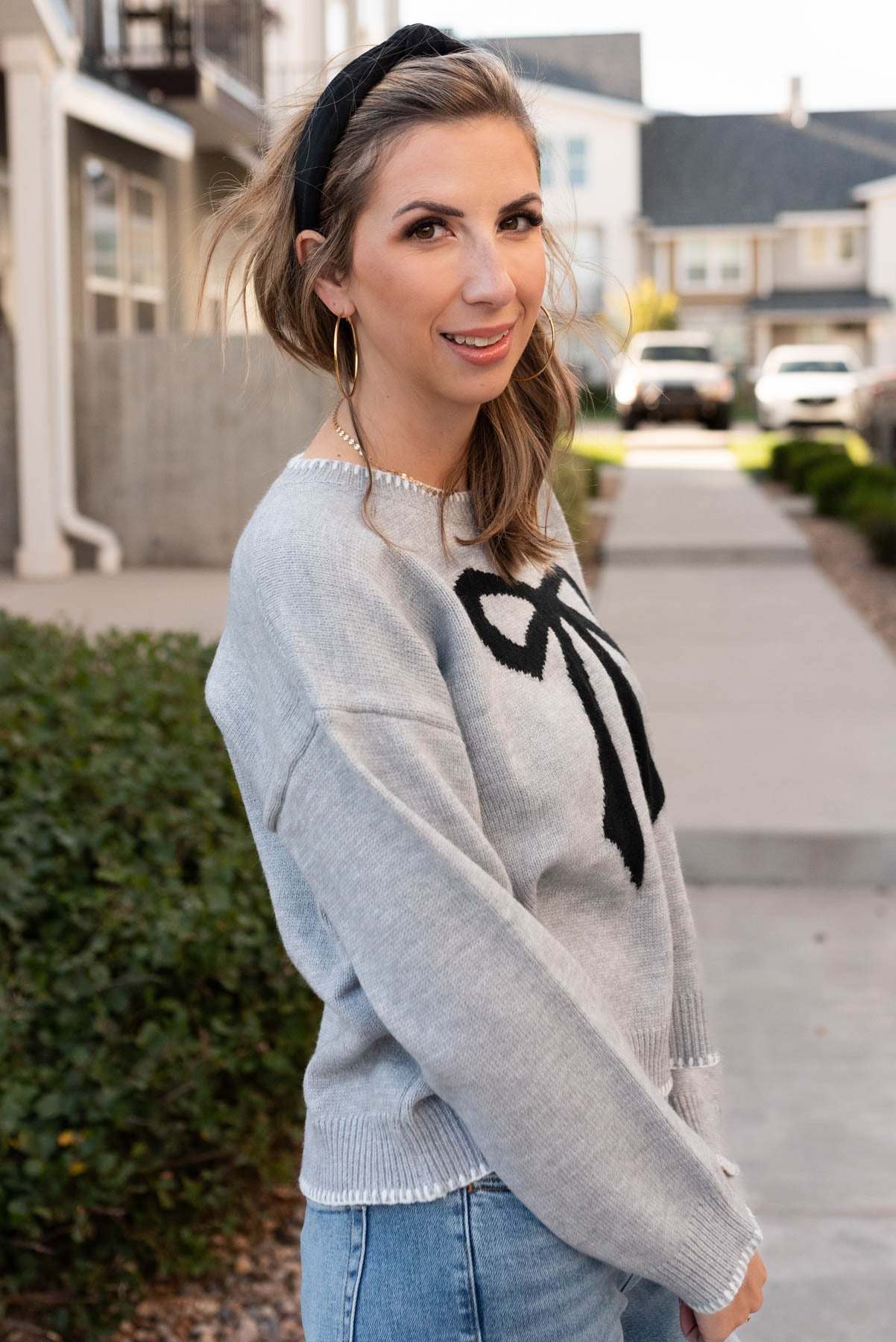 Side view of the heather grey bow sweater