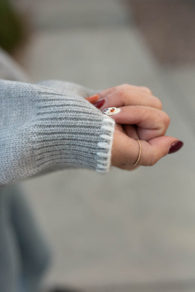 Close up of the white trim stitching on the heather grey bow sweater