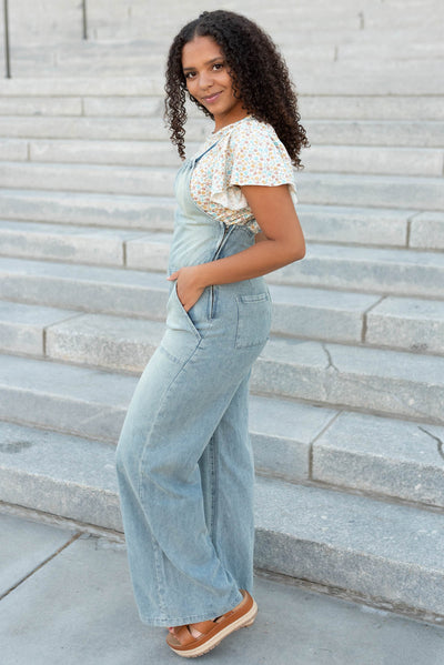 Side view of the denim jumpsuit with pockets