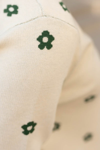 Close up of the green flowers on the cream green floral sweater