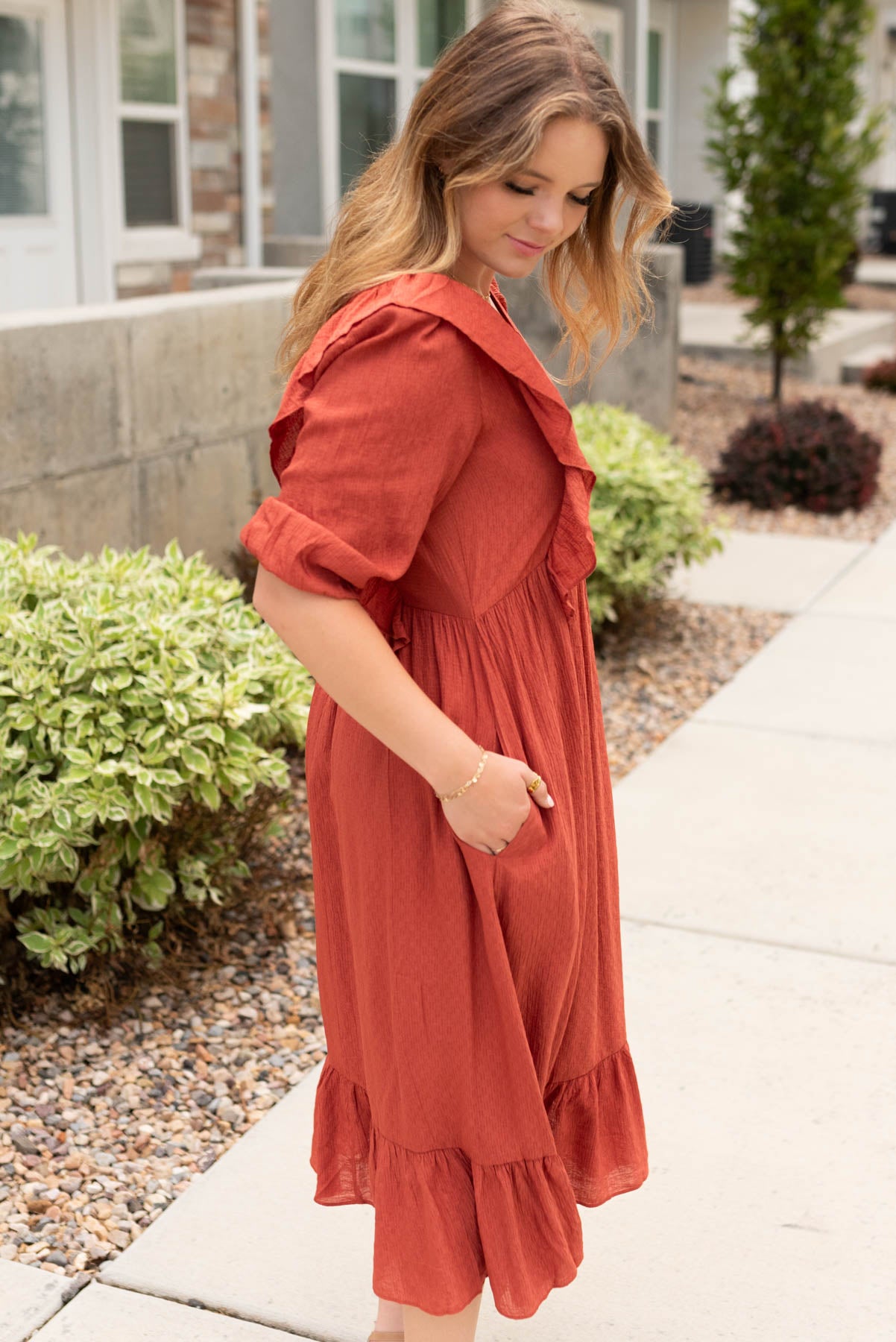 Side view of the rust mid dress with pockets