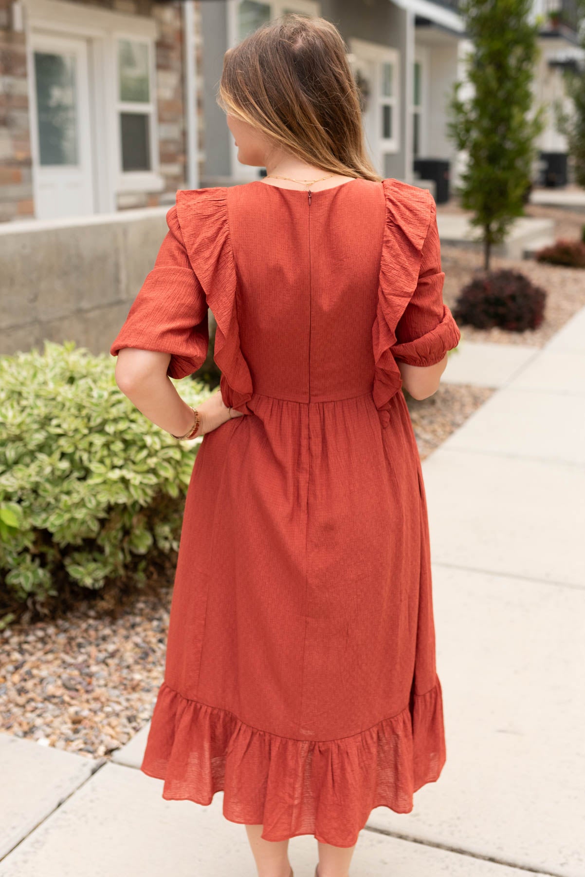 Back view of the rust midi dress with ruffles