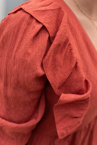 Close up of the ruffles on the bodice of the rust midi dress