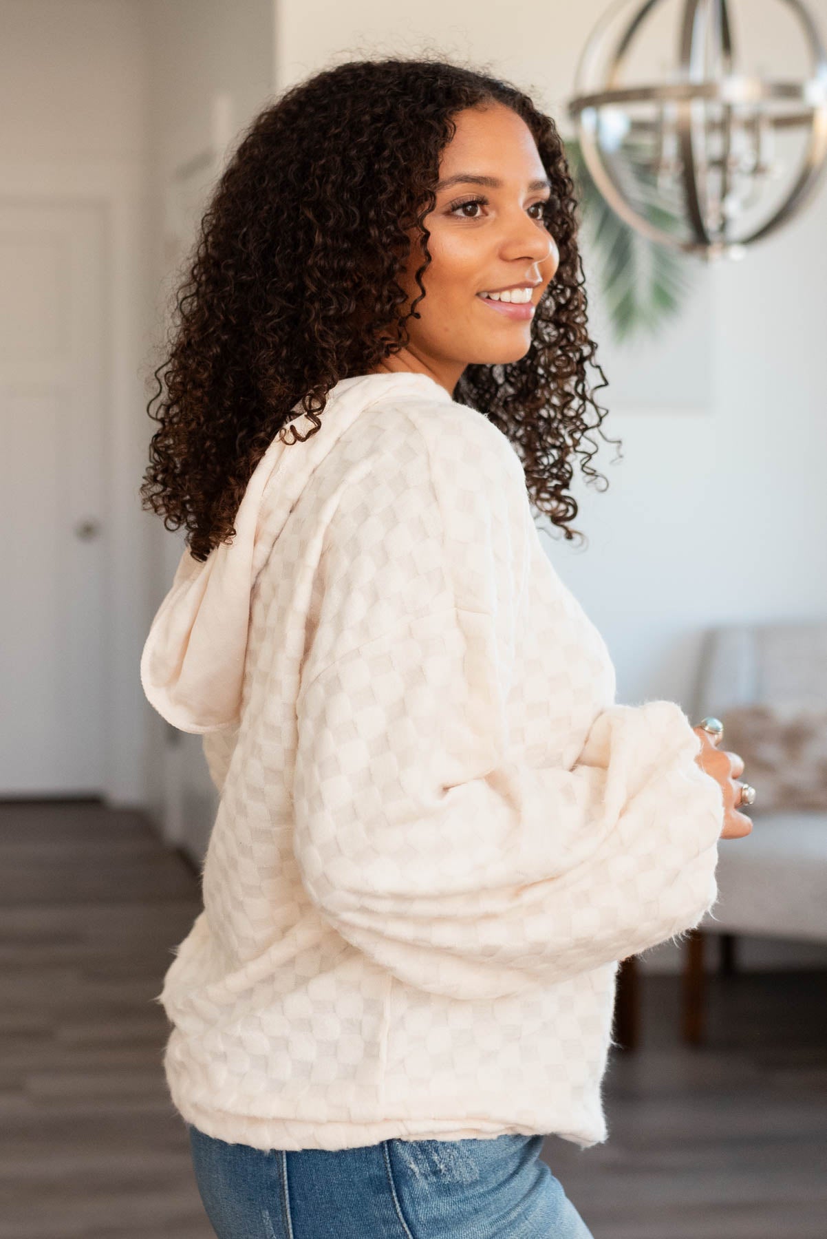 Side view of the ivory fuzzy checkered sweater with a hood