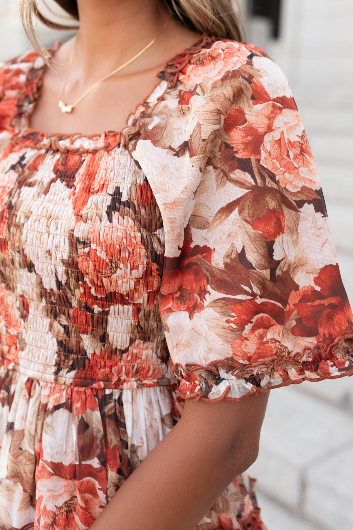 Close up of the sleeves and bodice on the rust flroal ruffle dress