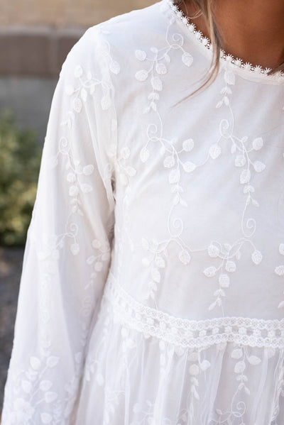 Close up of the lace trim and the fabric on the white floral maxi dress