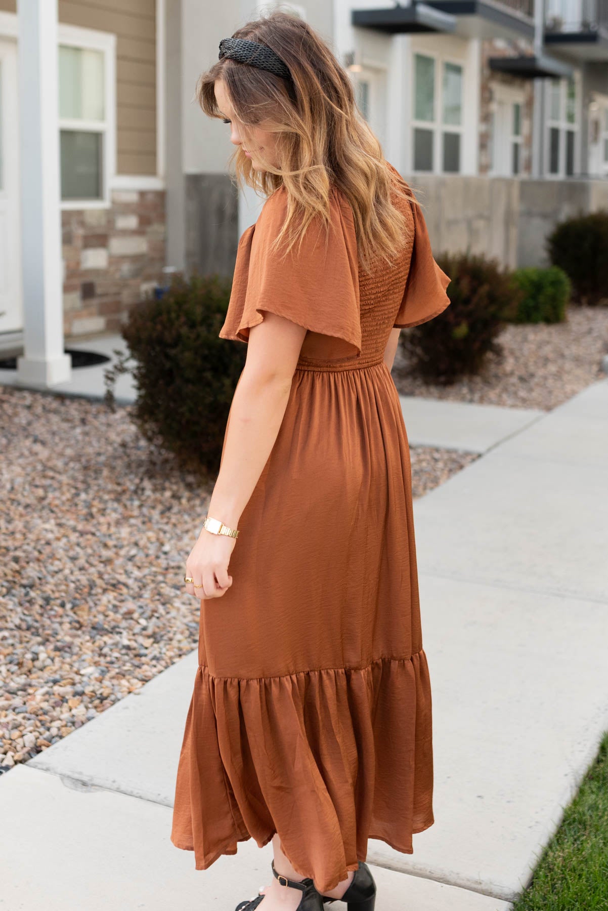 Side view of the sepia satin dress with a ruffle at the hem