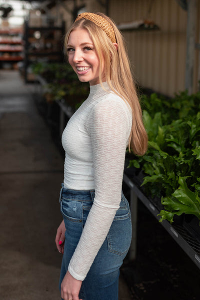 Side view of the white floral stretch lace top