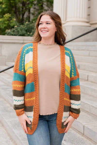 Front view of the color block rust cardigan in plus size