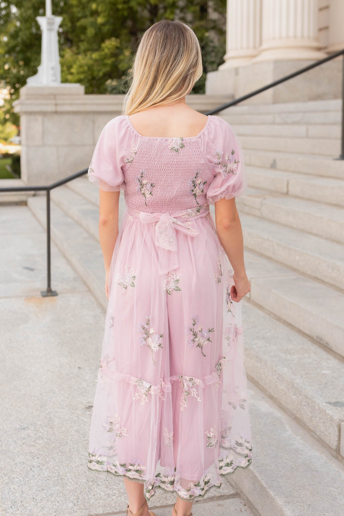 Back view of the dusty pink embrodered dress with tie a the waist in the back