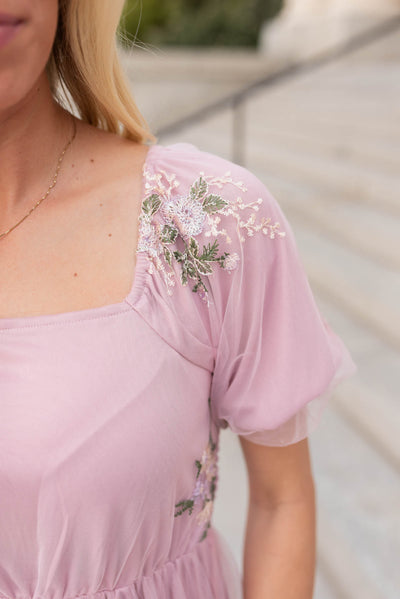 Close up of the sleeve and neckline on the dusty pink embroidered dress