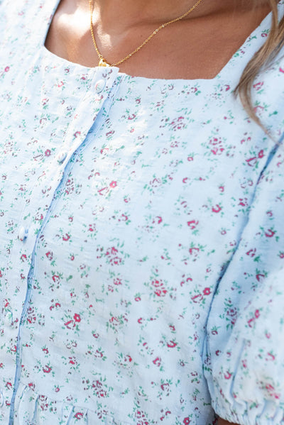 Close up of the neckline and buttons on the light blue floral dress