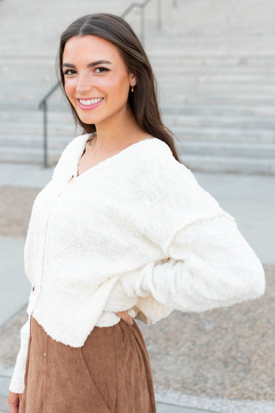 Side view of the button up oatmeal sweater