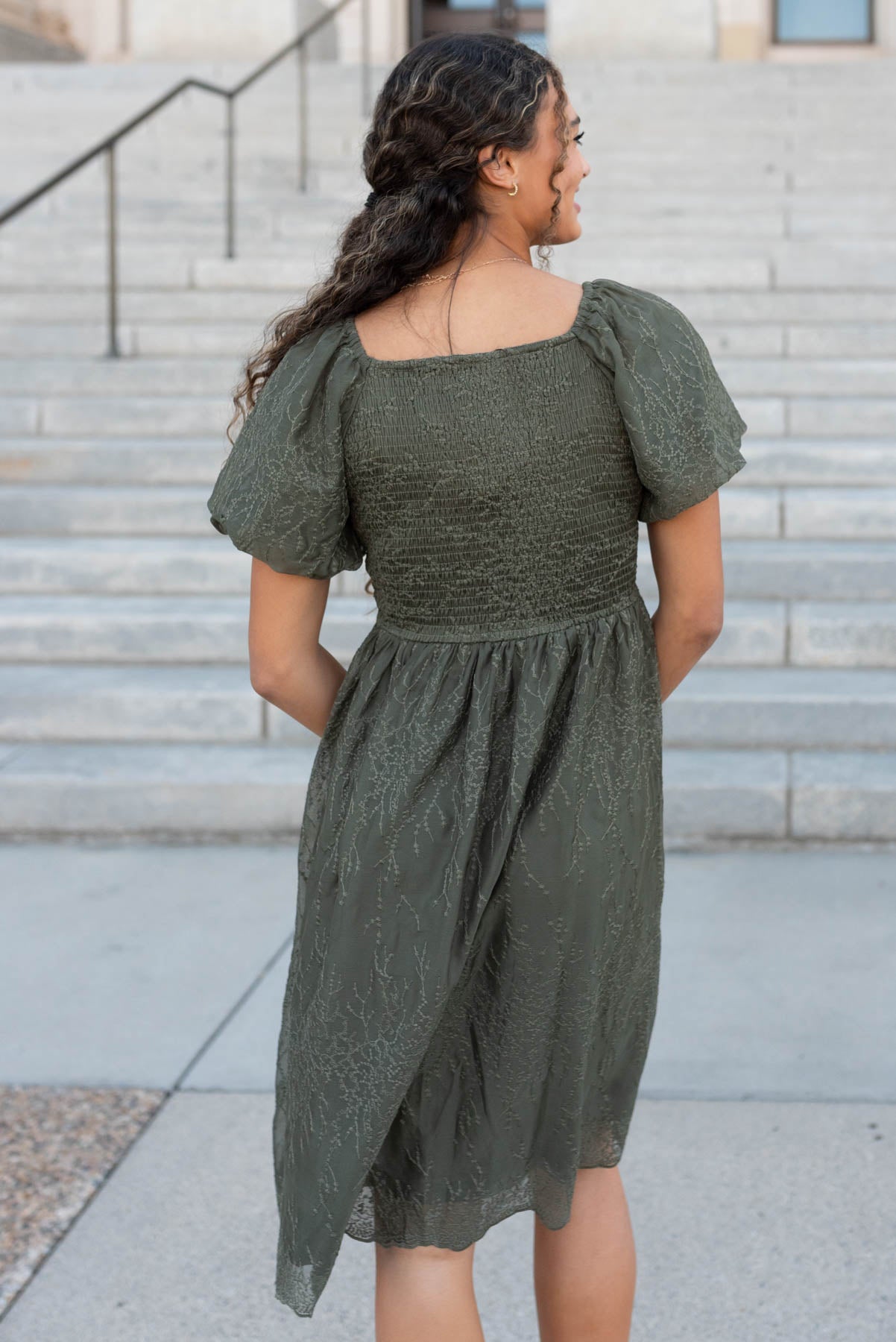 Back view of the olive embroidered square neck dress with smocked dress