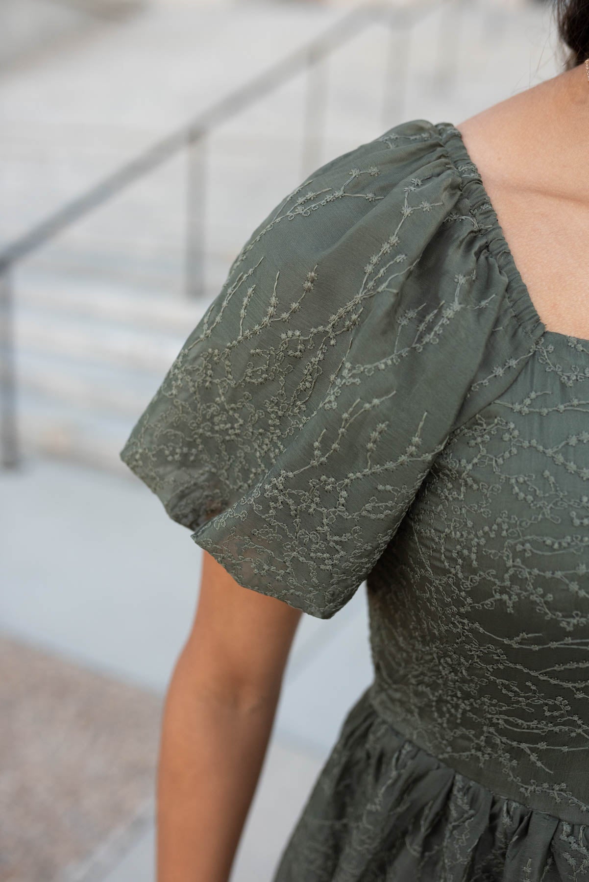 Close up of the sleeve and fabric on the olive embroidered square neck dress