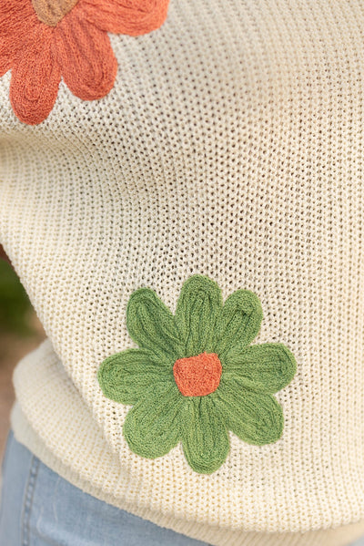 Close up of the flowers on the cream floral sweater