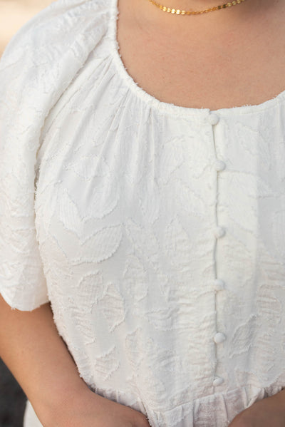 Close up of the bodice on the plus size white woven pattern dress