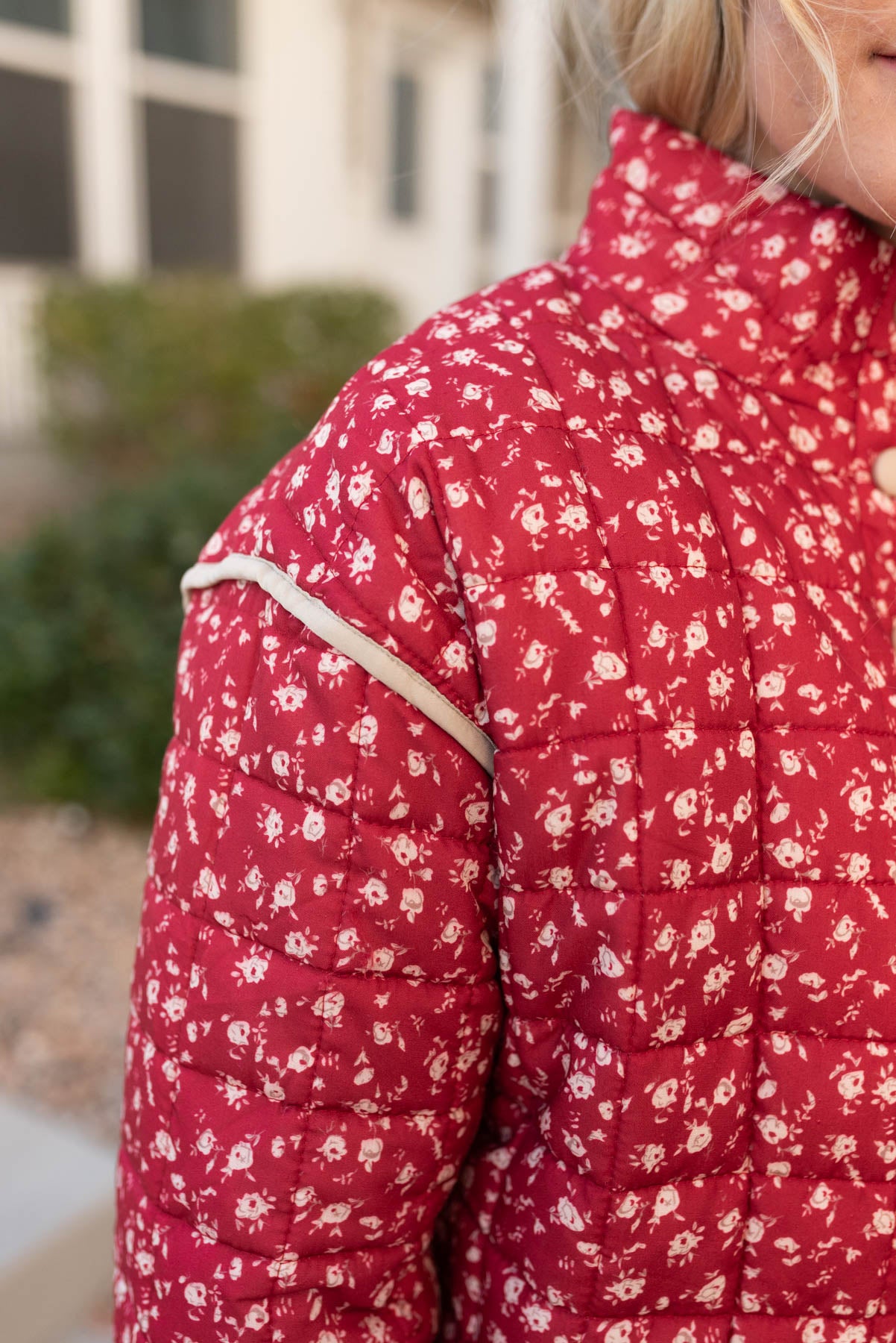 Close up of the trim on the shoulder on the red floral quilted jacket