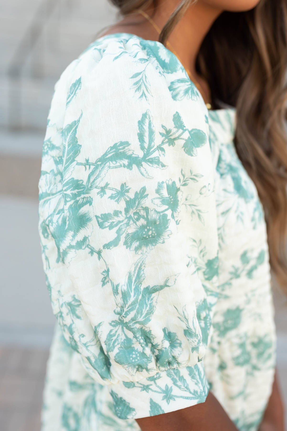 Close up of the sleeves and fabric on the green floral tiered dress