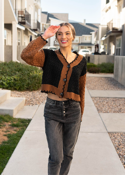 Black knit cardigan with rust sleeves and trim