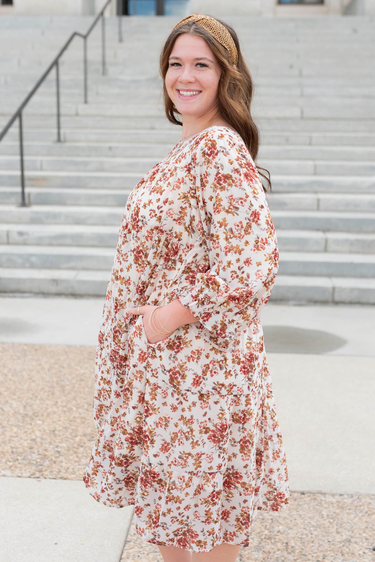 Side view of the plus size cream flroal tiered dress with pockets