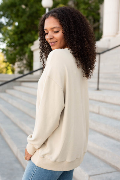 Side view of the beighe embroidered blow pullover