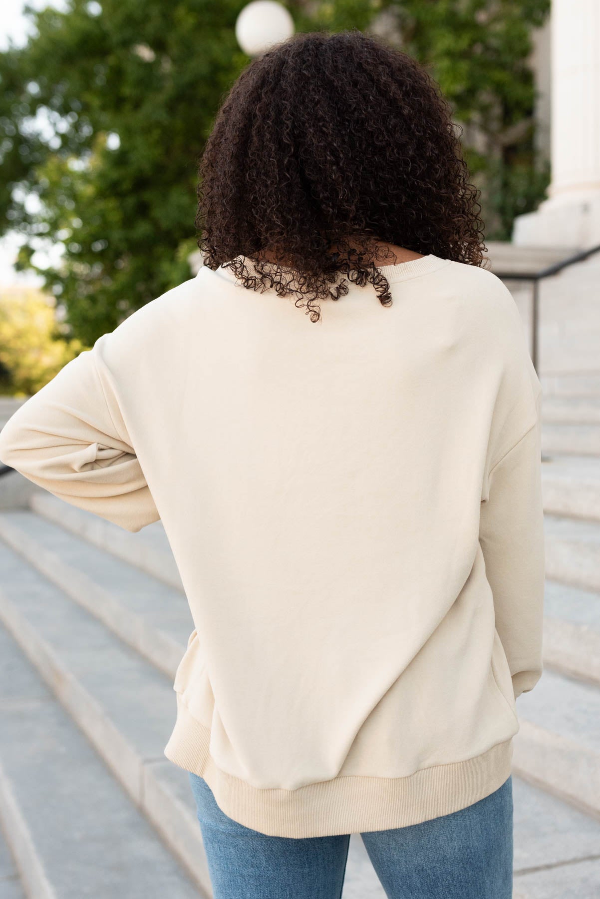 Back view of the beige embroidered bow pullover