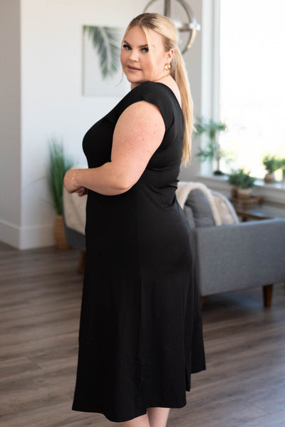 Side view of a plus size black slipette midi cap sleeve