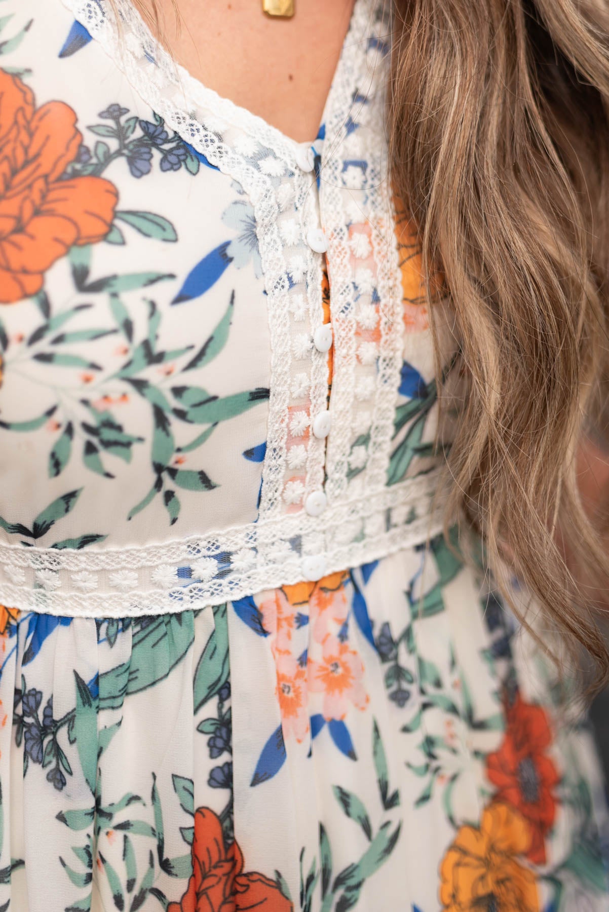 Close up of the lace trim on the cream floral tiered dress