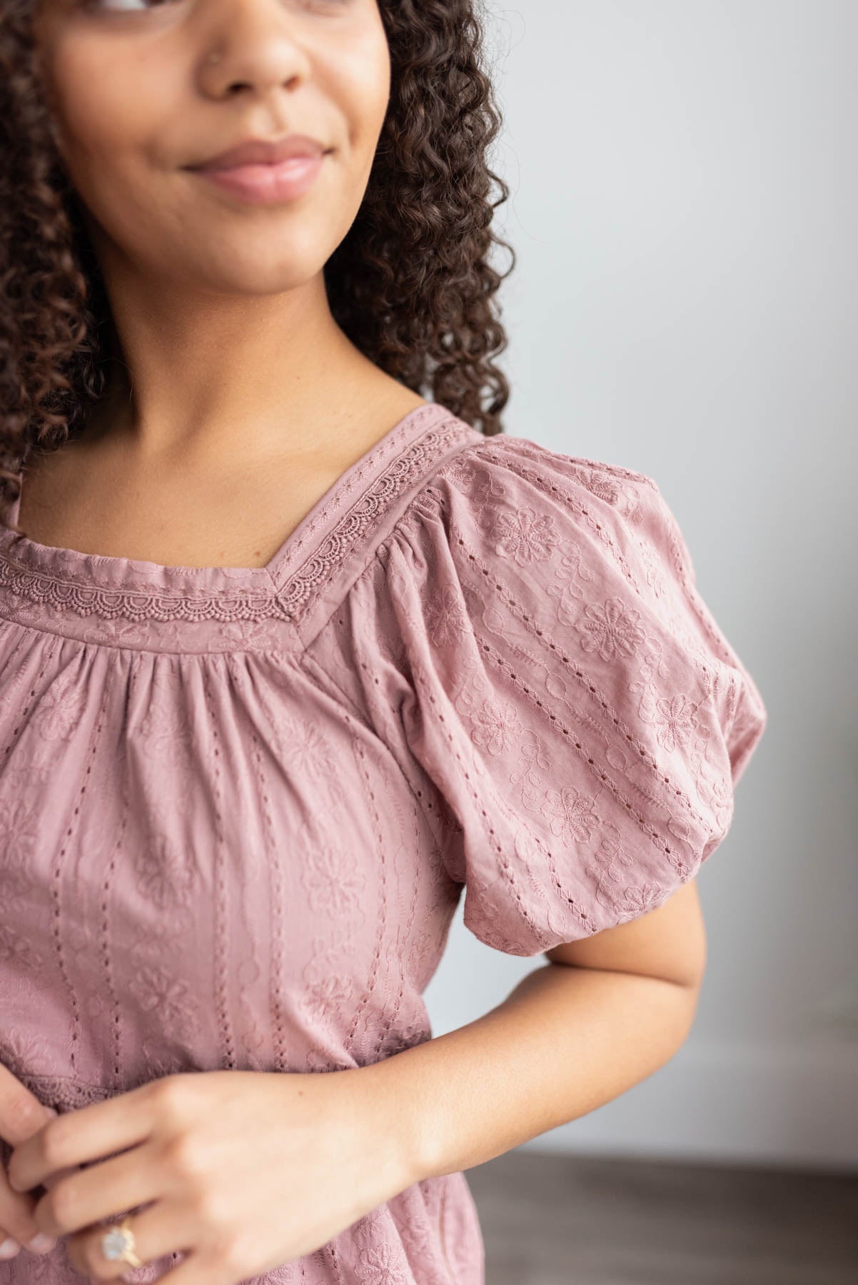 Close up of the fabric and lace on the mauve embroidered dress