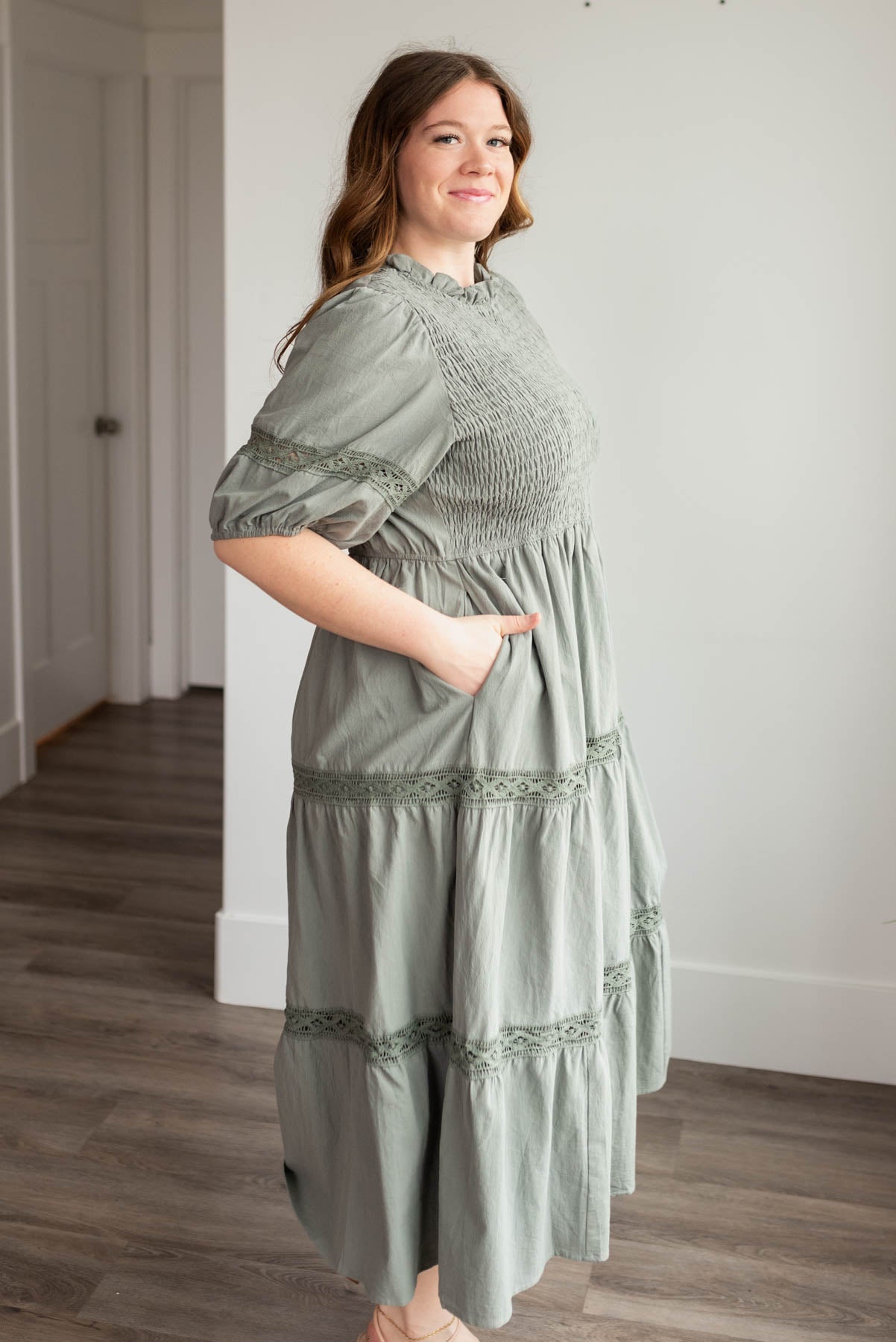 Side view of the dark sage tired dress in plus size with pockets