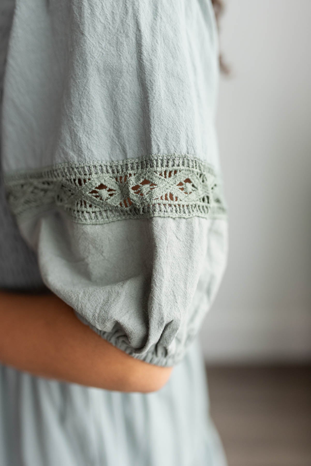 Close up of the sleeve and lace on the dark sage tiered dress