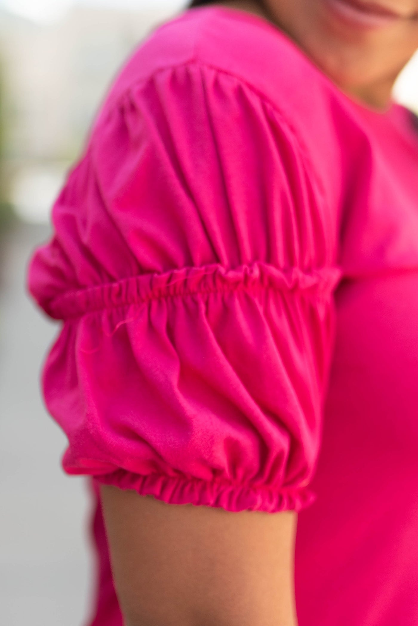 Sleeve of a dark fuchsia top