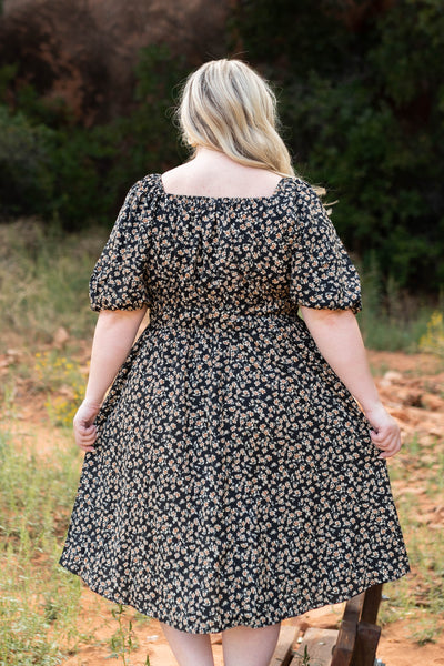 Back view of a plus size black floral dress