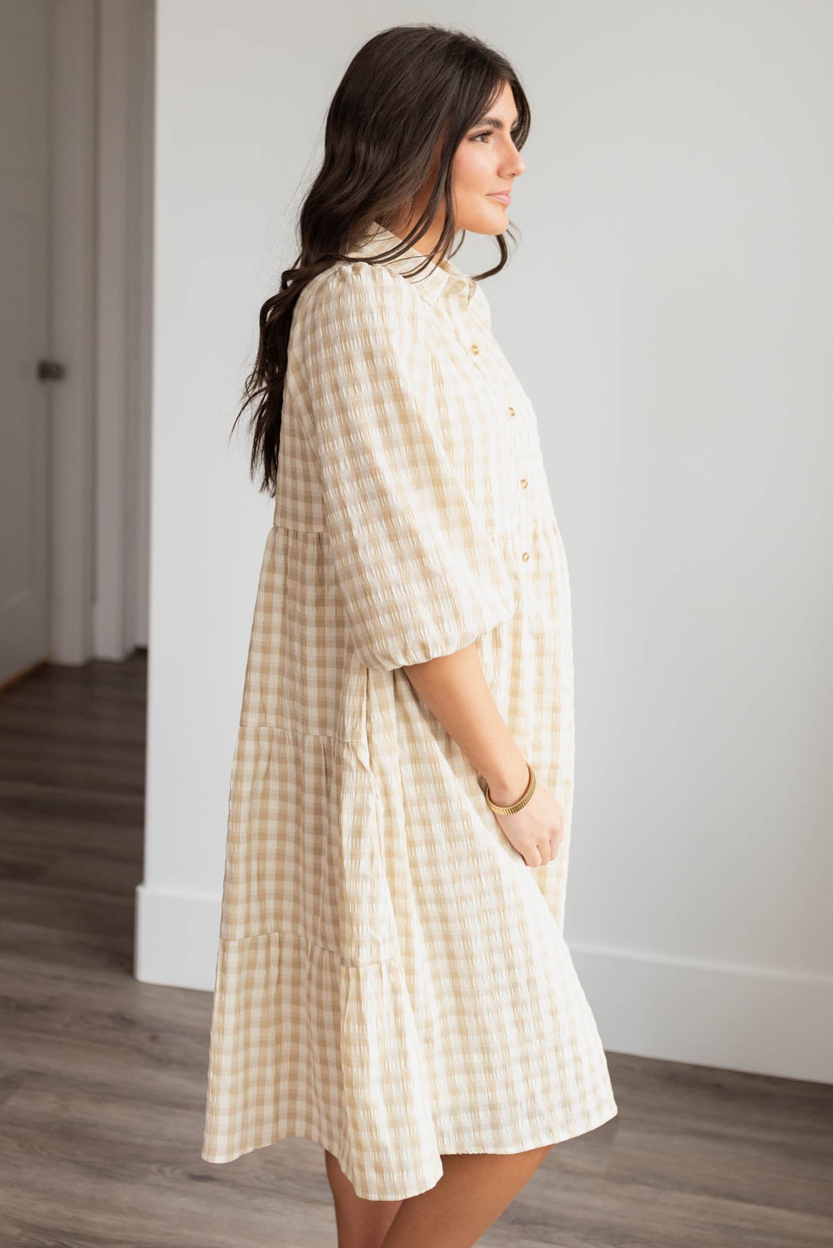 Side view of the beige gingham button down dress