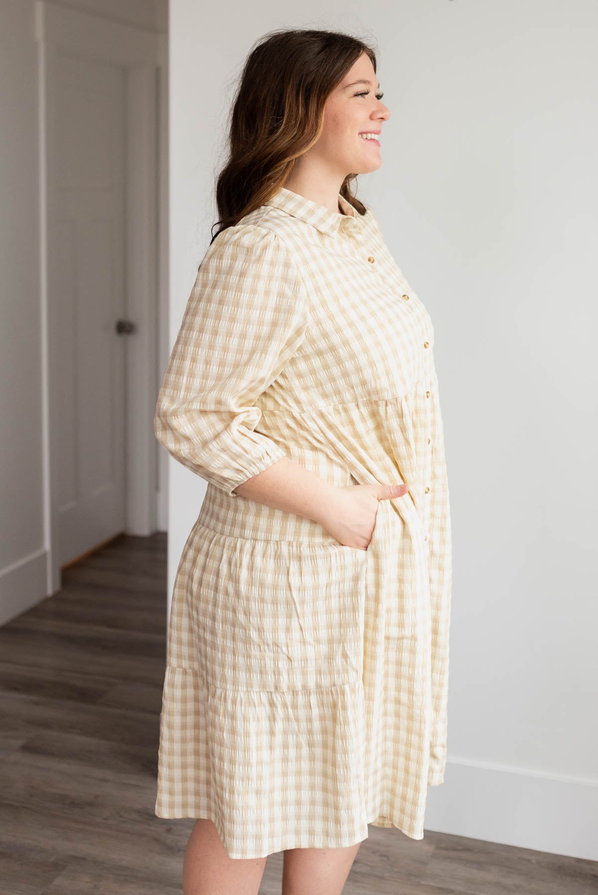 Side view of the beige gingham button down dress in plus size