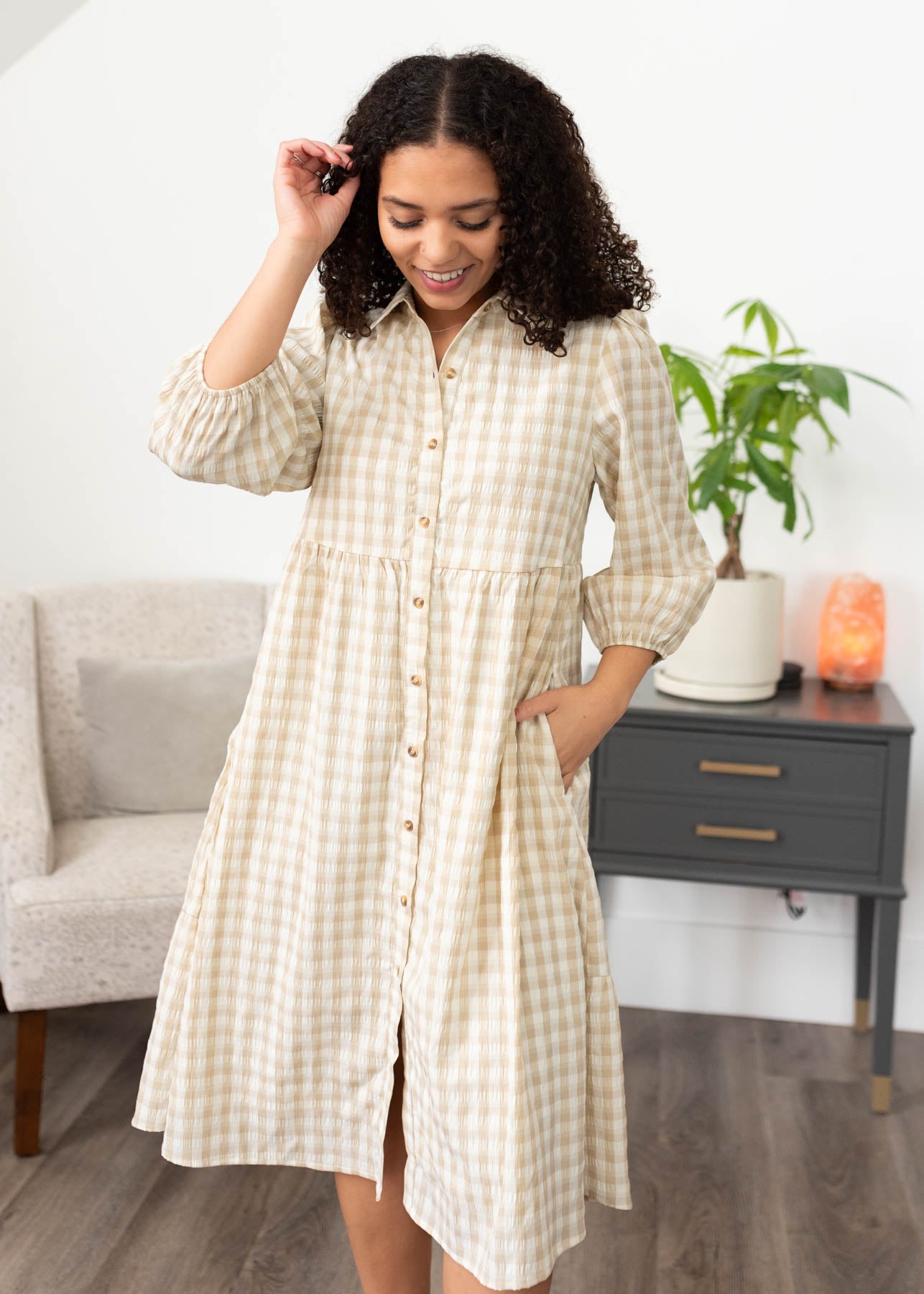 Front view of the taupe gingham button down dress with pockets