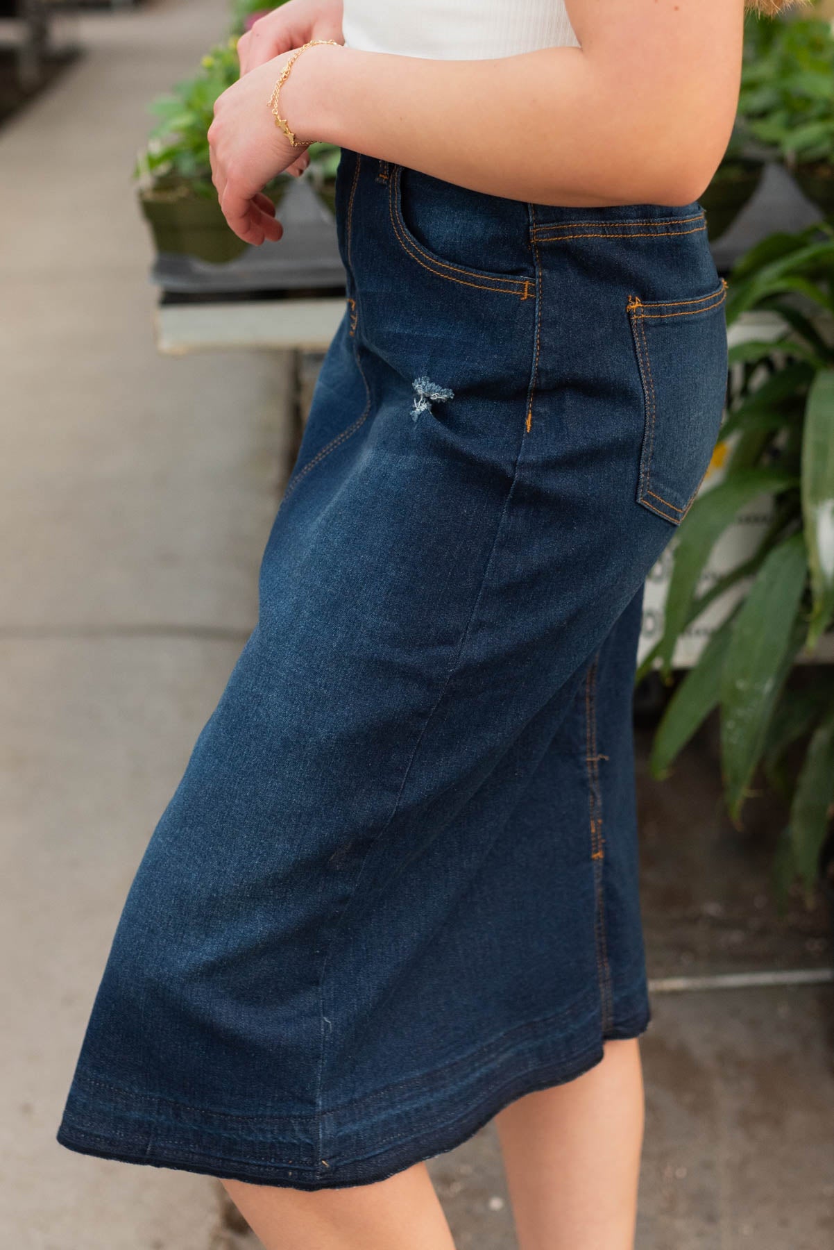 Side view of the dark denim distressed skirt