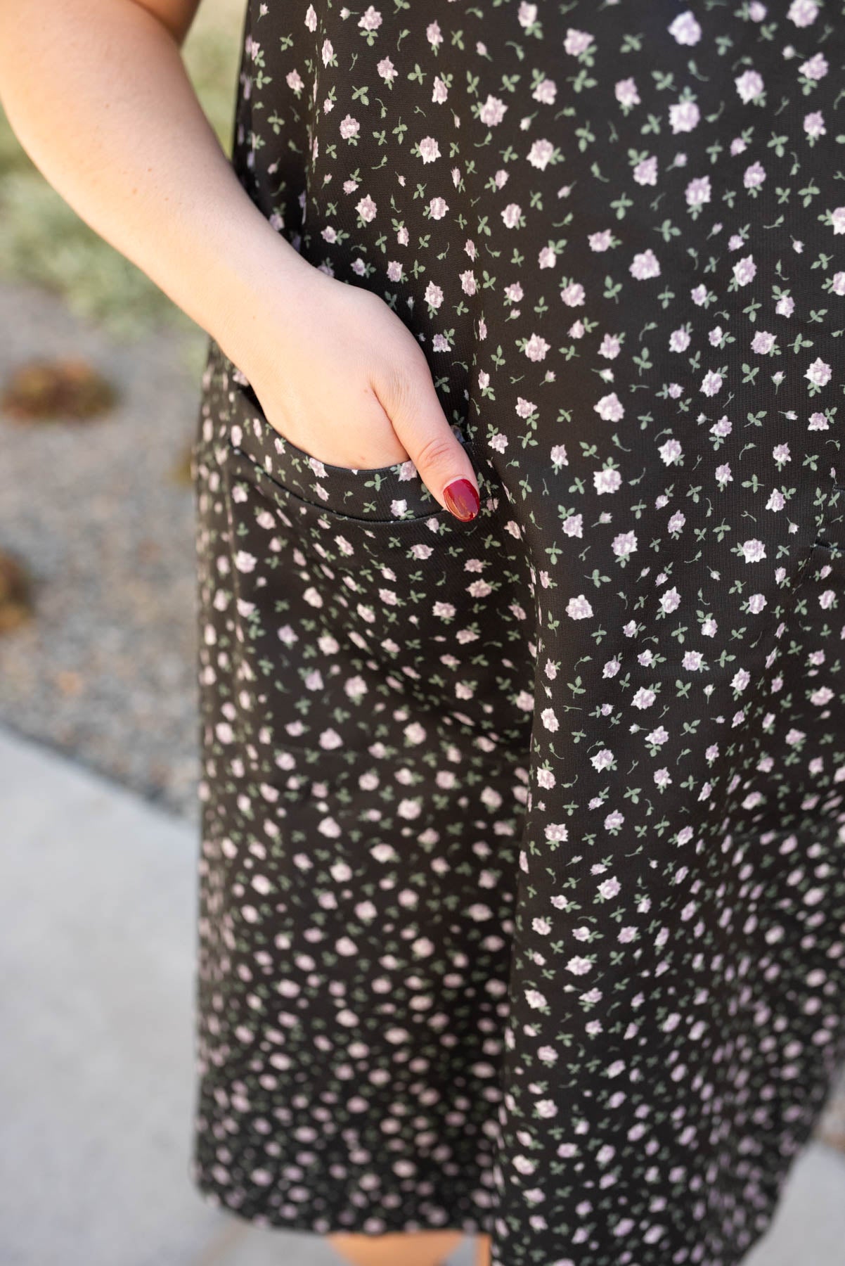 Close up of the fabric and pocket on the black floral jumper dress