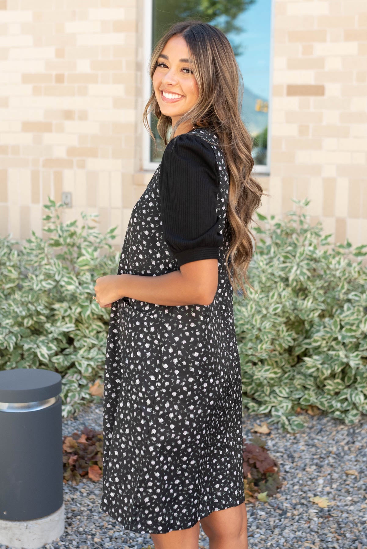 Side view of the black floral jumper dress