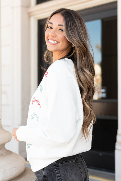 Side view of the white christmas bow sweater