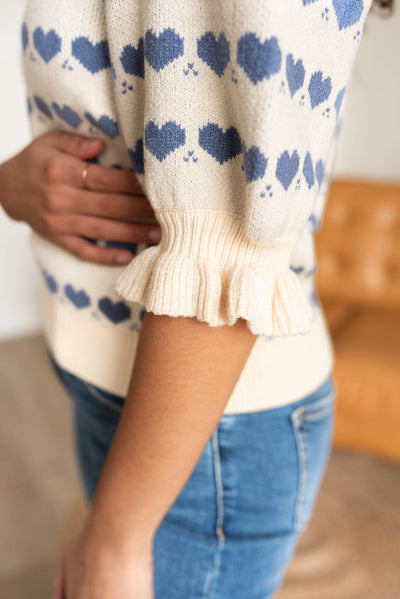 Close up of the sleeve and ruffle on the heart stripe sweater