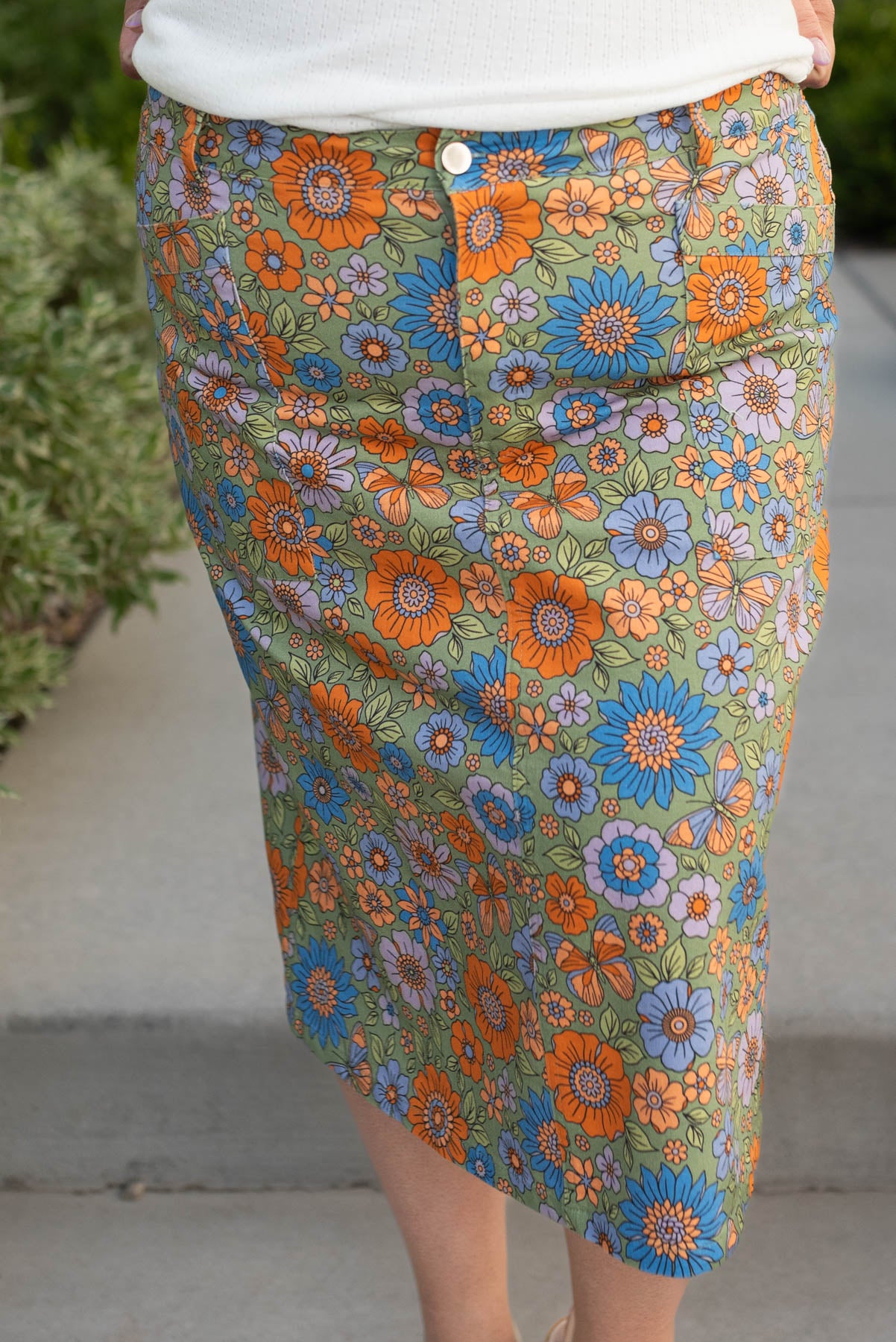 Front view of the plus size green multi floral jean skirt