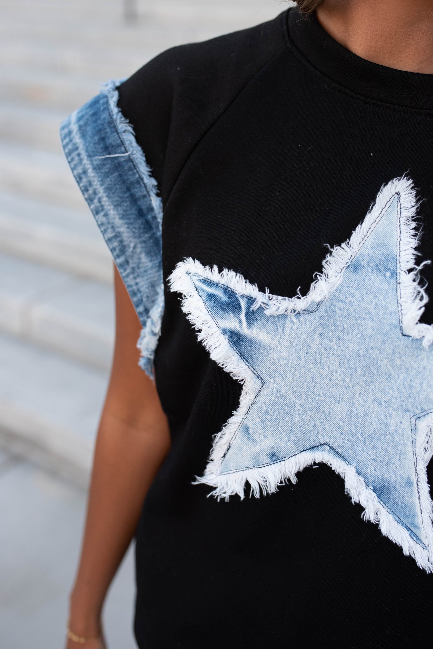 Close up of the black denim star top