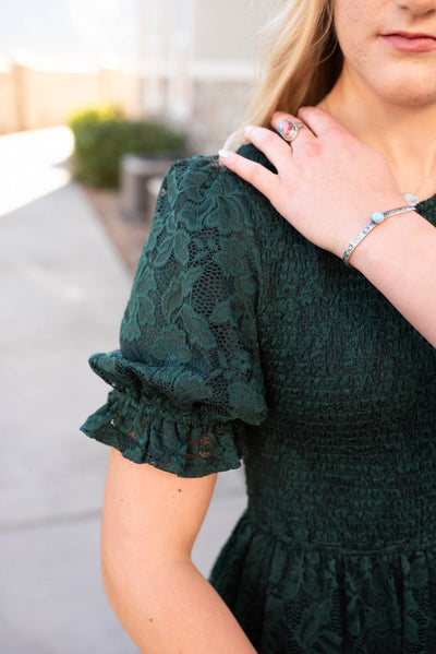 Close up of the sleeve and fabric on the emerald green lace dress