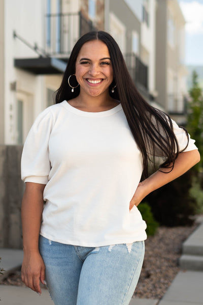 Cream top with short sleeves and cuffs