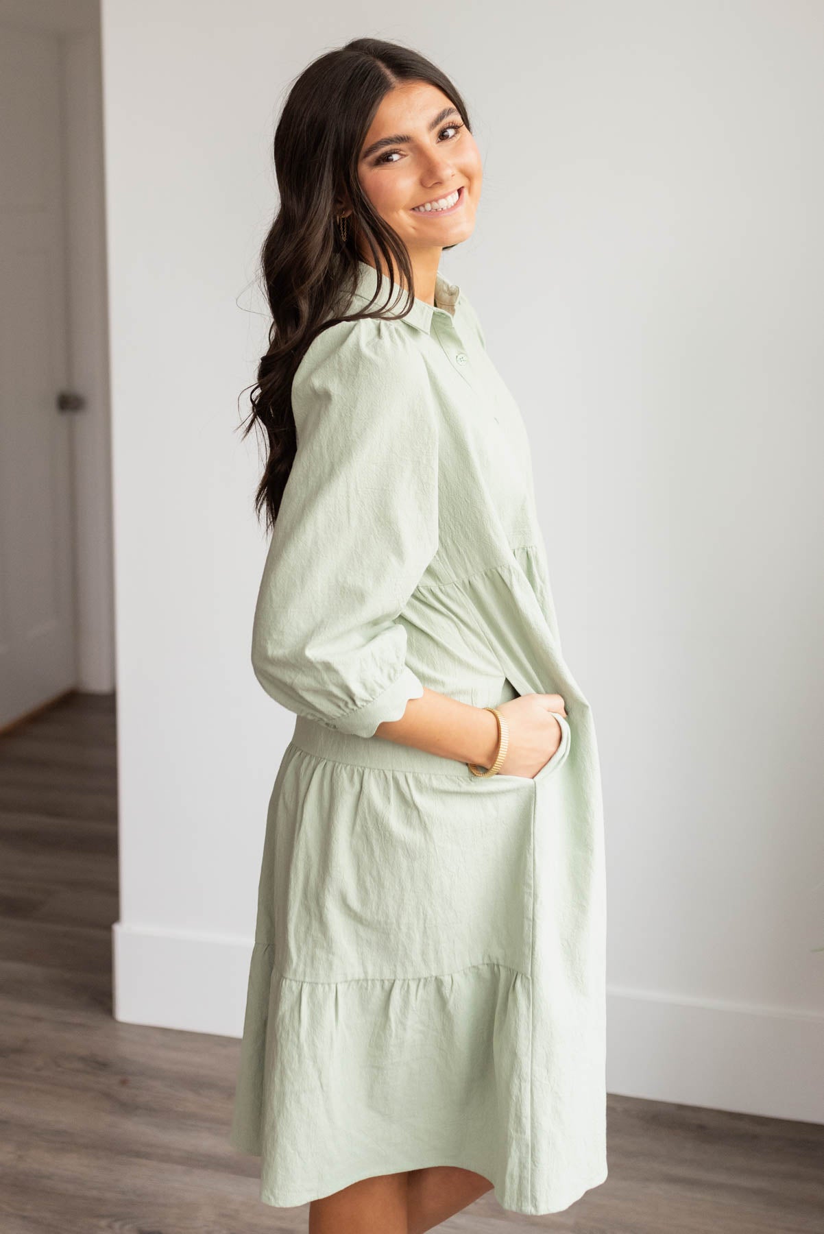 Side view of the green button down dress with pockets