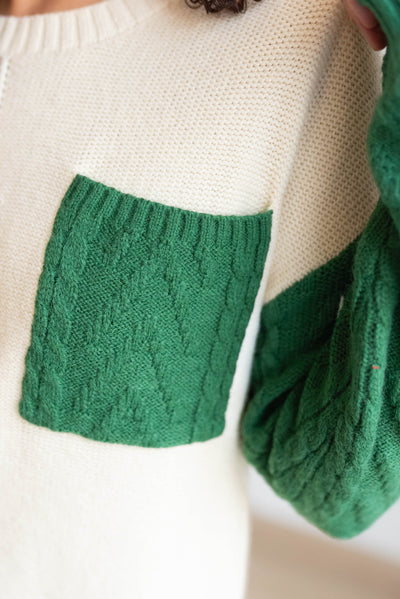 Close up of the color block sweater and it's green pocket