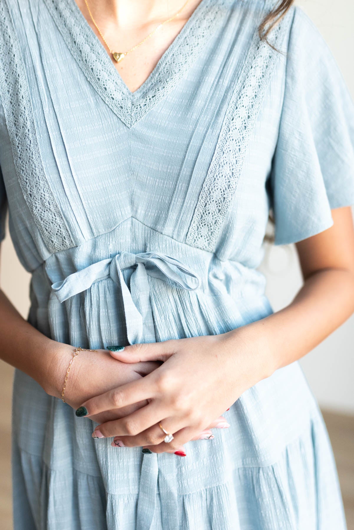 Close up of the fabic and the lace trim of the dusty blue textured tiered dress