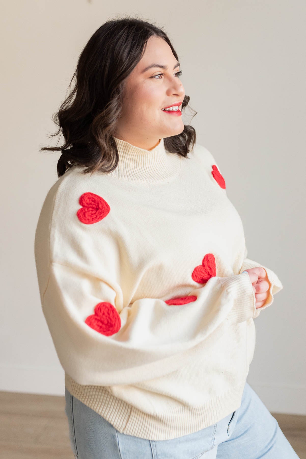 Side view of the red heart cream sweater in plus size